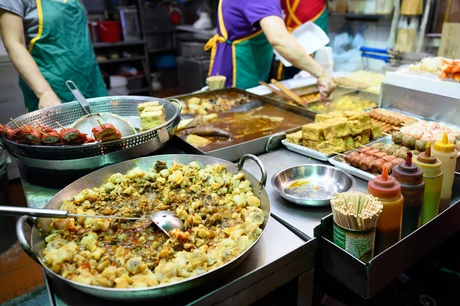 Negocio de comida callejera en un mercado por la noche.